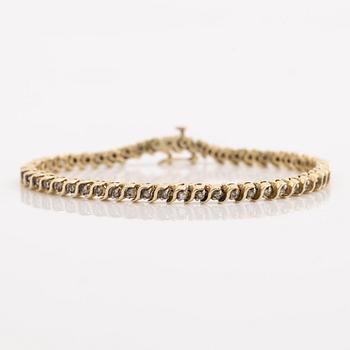 Tennis bracelet 14K gold with round brilliant-cut diamonds.