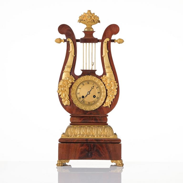 A French Empire mahogany, ormolu and gilt metal lyre-shaped mantel clock, early 19th century.