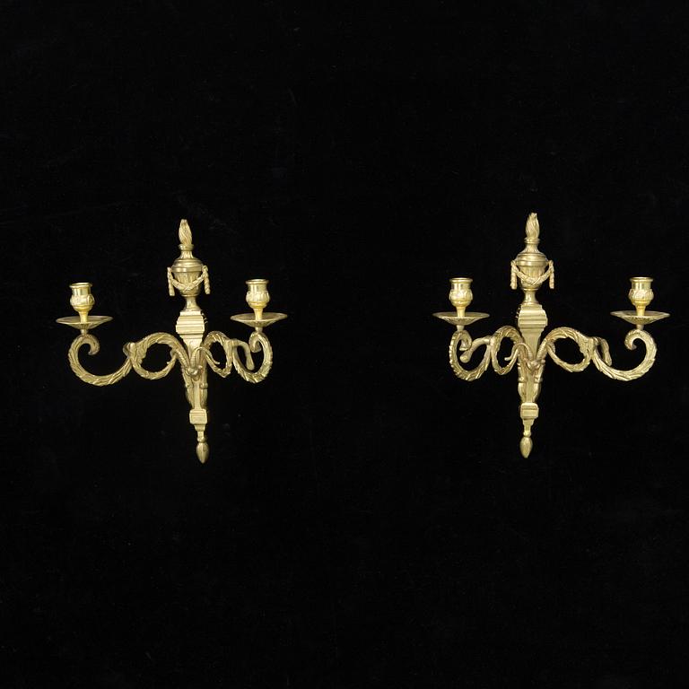 A pair of Louis XVI style brass wall appliques, first half of the 20th Century.