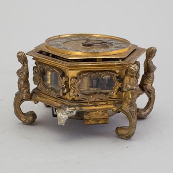 A gilded brass baroque travel clock from around 1700, with original case.