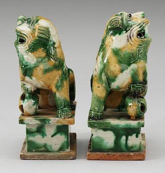 A pair of green and yellow glazed bisquit cencers, in the shape of sitting Buddhist lions, Qing Dynasty, Kangxi (1662-1722).