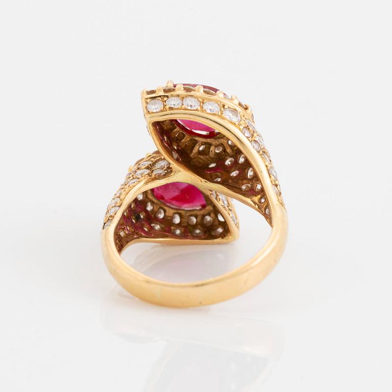 An 18K gold ring set with two facted rubies and round brilliant-cut diamonds.