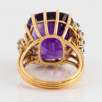 An 18K gold ring set with a faceted amethyst and round brilliant-cut diamonds.