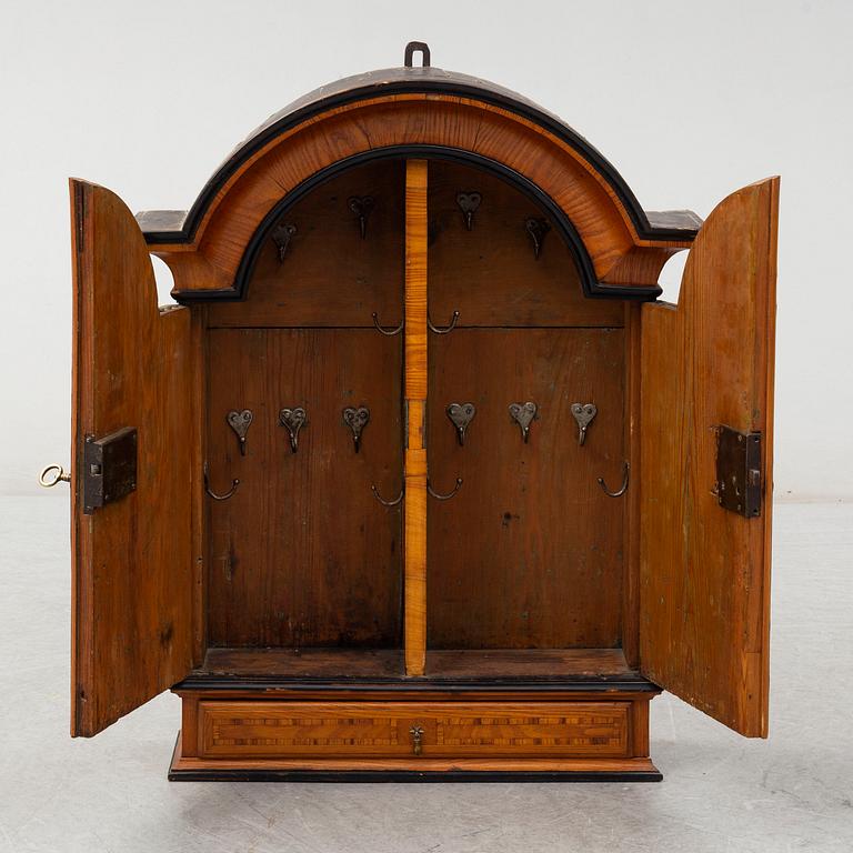 A first half of the 18th century late baroque elm veneered wall cabinet.