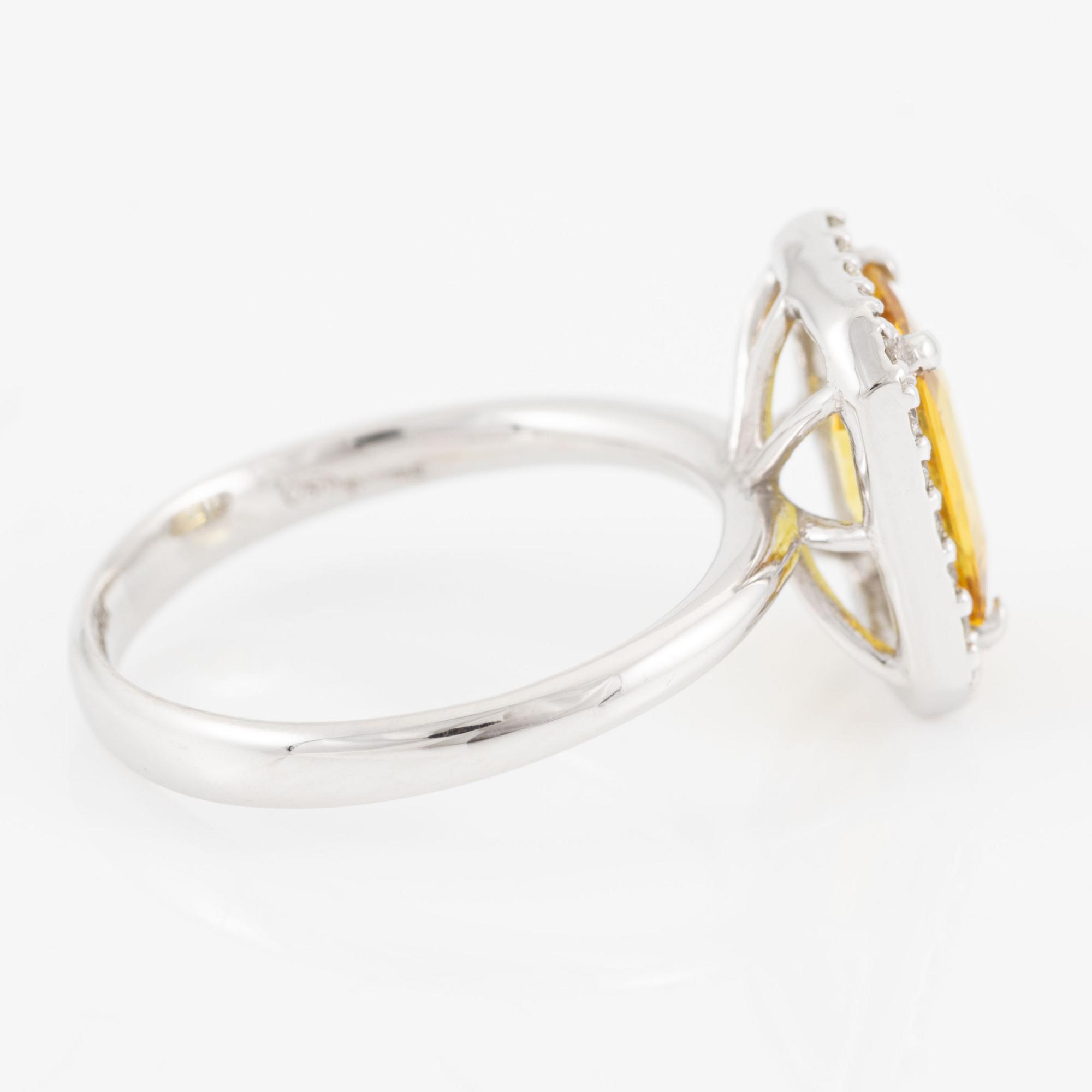 Ring 18K guld med en fasettslipad safir och runda briljantslipade diamanter.