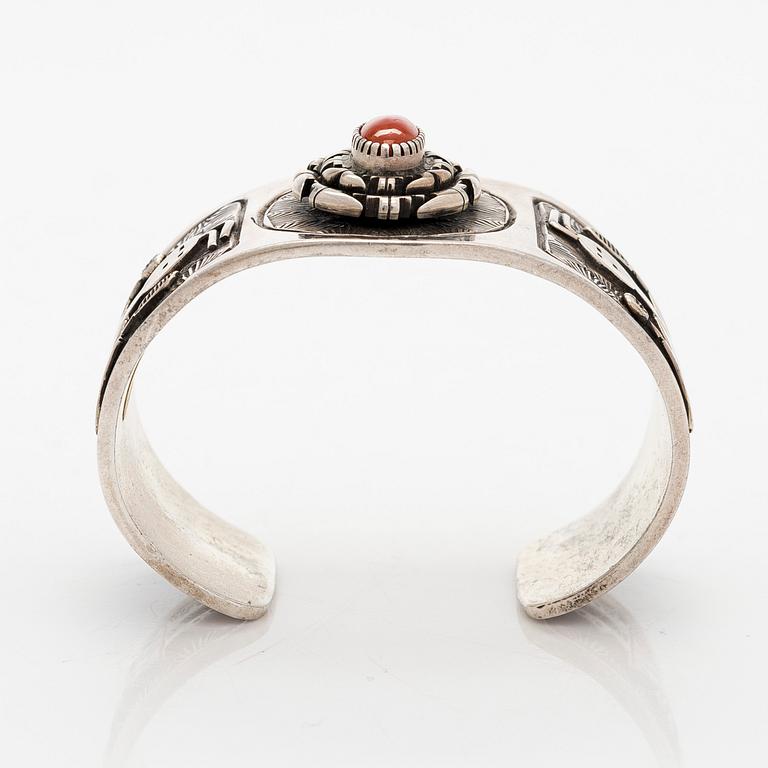 A silver bracelet with coral.