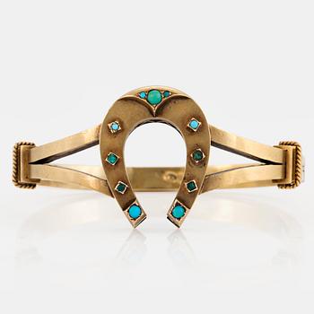 1065. A 14K gold horse shoe bangle set with turquoises.