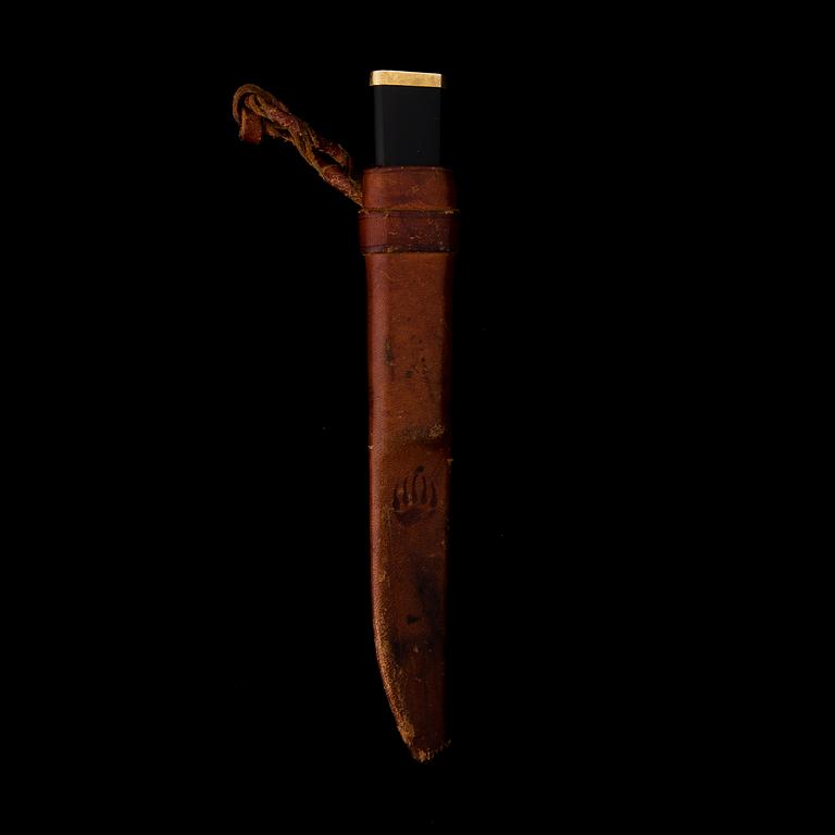 A Finnish puukko knife in stainless steel, nylon and brass designed by Tapio Wirkkala, Hackman Finland.