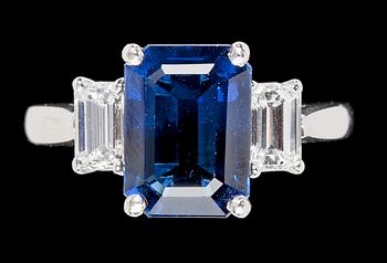 963. RING, trappslipad blå safir, 4.55 ct med två smaragdslipade diamanter, tot. 0.80 ct.
