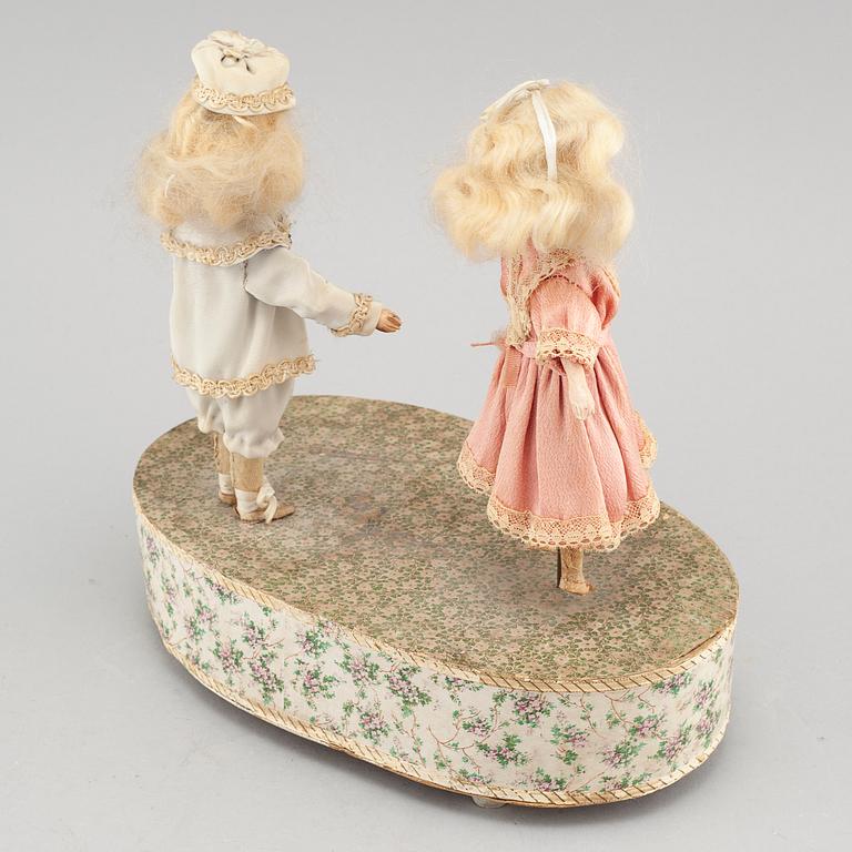 Dolls on a music box, around year 1900.