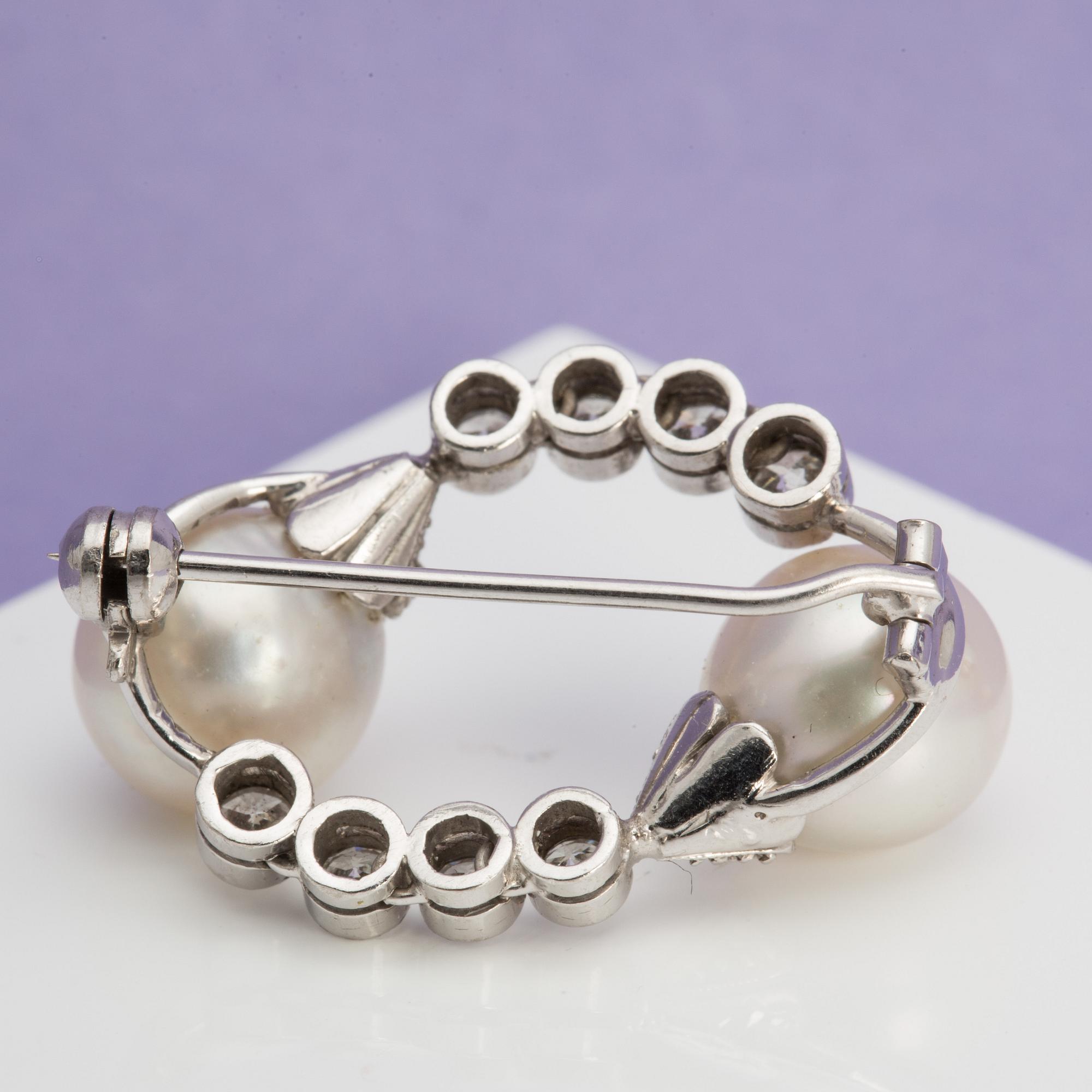 A ca 0.40 ct brilliant-cut diamond brooch with two freshwater pearls.