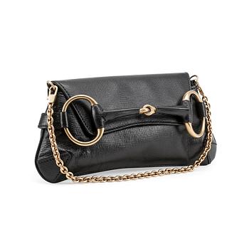 510. GUCCI, a black embossed leather clutch with a shoulder strap.