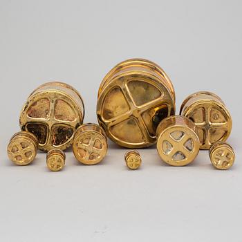 A set of nine brass measures, The Oriental Metal Pressing Works, Ltd, Bombay, Indien, 20th Century.