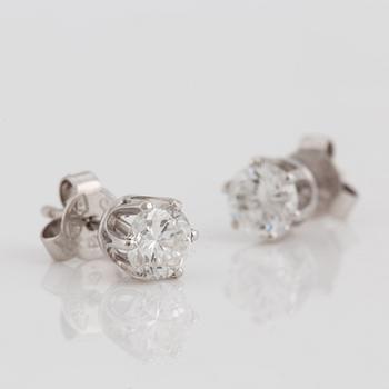 A pair of brilliant cut diamond earrings.