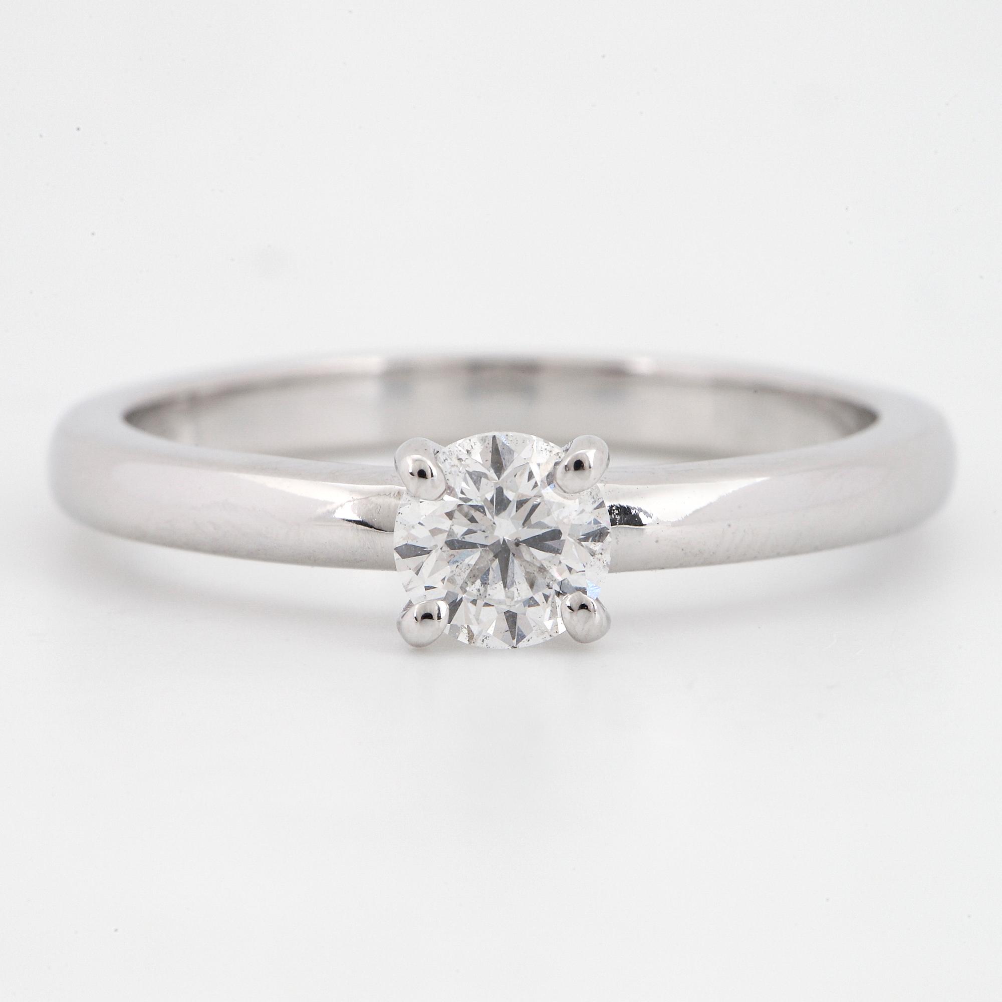 An 18K white gold ring set with a round brilliant-cut diamond.