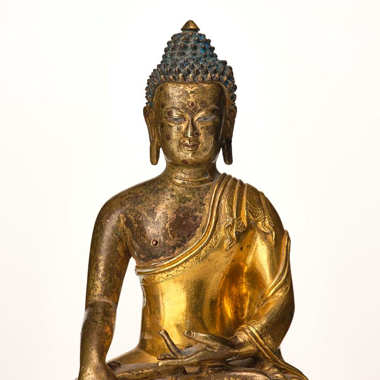 A Tibeto Chinese style gilt copper alloy figure of Buddha.