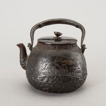 A Japanese iron tea pot with bronze cover, signed.