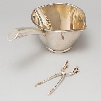 A Mexican sterling silver sauce pan and a Georg Jensen sugartangs, 20th century.