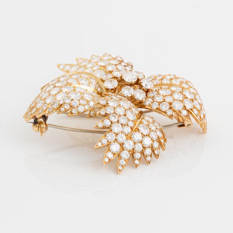 A Van Cleef & Arpels flower brooch in 18K gold set with round brilliant-cut diamonds.