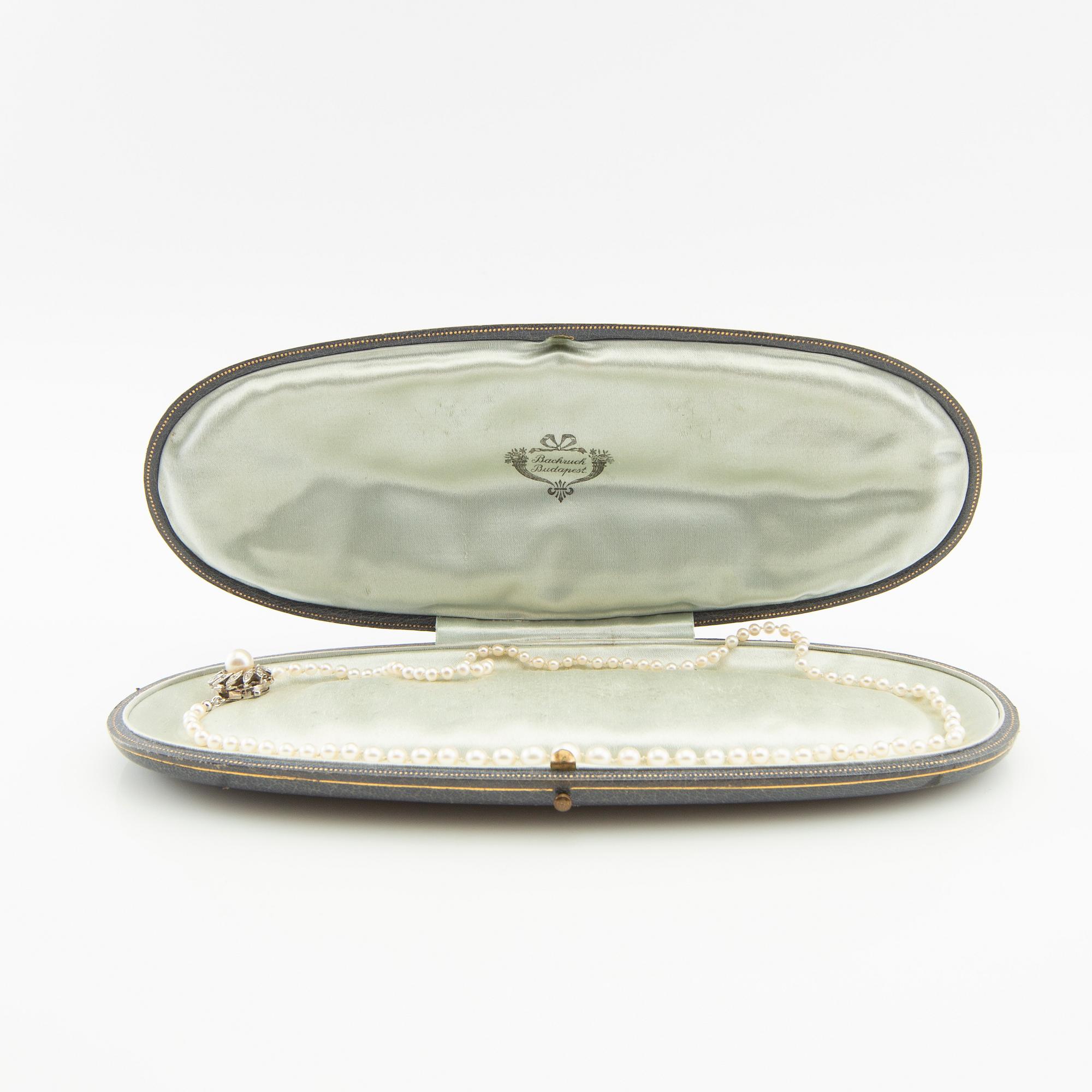 Necklace of cultured pearls and a clasp of 18K white gold set with round brilliant-cut diamonds and a cultured pearl.