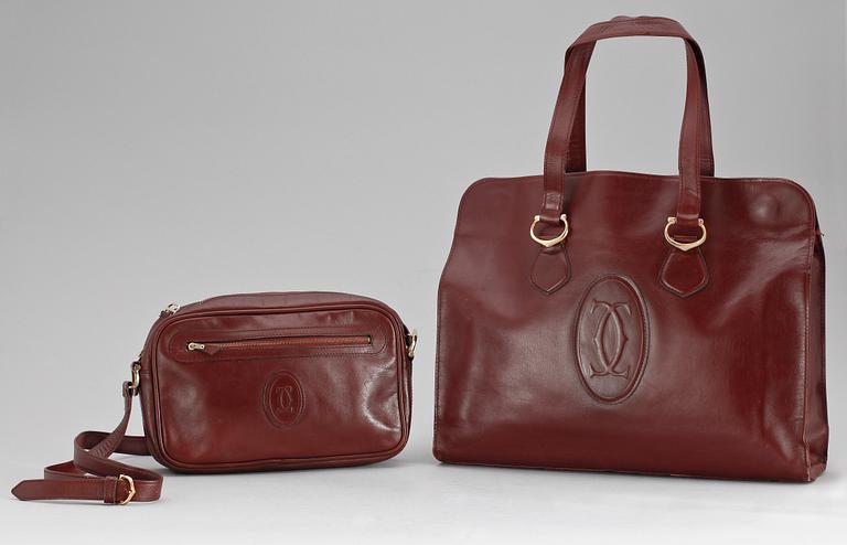 A set of two 1970s bordeaux leather handbags by Cartier.