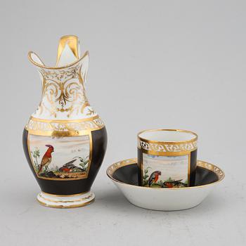 A porcelain jug and a cup with saucer, empire style, circa 1900.