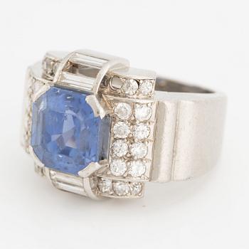 A platinum ring with a faceted sapphire and round brilliant-, eight-, and baguette-cut diamonds.