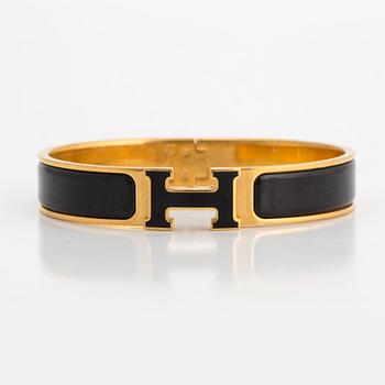 Black enamel and golden bracelet "Clic H" by Hermès.