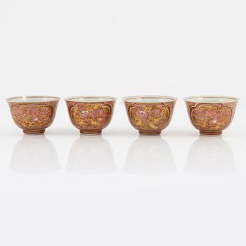 A set of four iron red and gilded wine cups, Japan, early 20th Century.