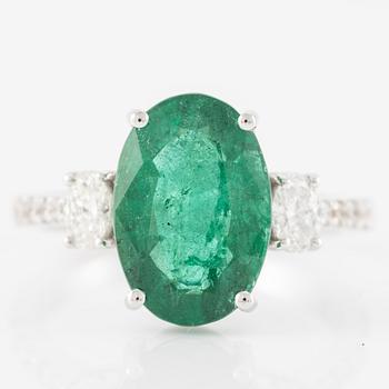 Ring in 18K white gold with an oval emerald and oval-cut and brilliant-cut diamonds.