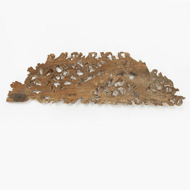 A carved and gilt wood wall decoration, rococo style from around the year 1900.