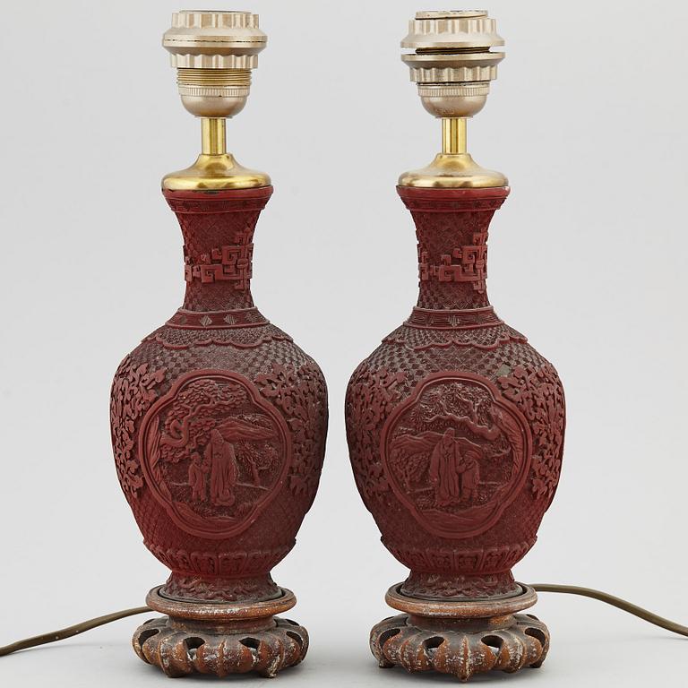 A pair of Chinese red lacquered vases, turned into table lamps, 20th century.