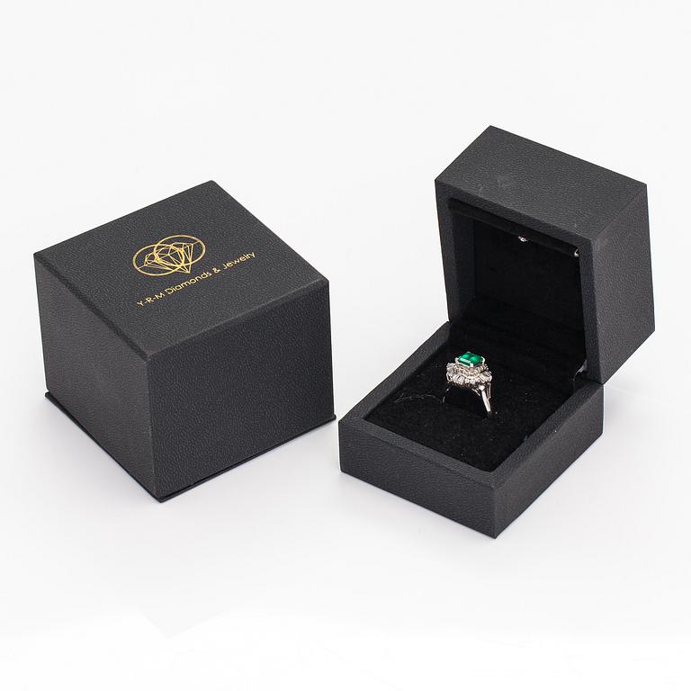 A platinum ring with a ca. 1.15 ct emerald and ca. 1.00 cts of diamonds in total.