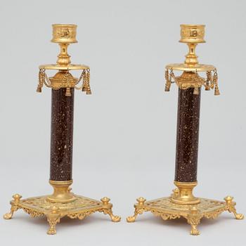 A pair of Swedish late 19th century brass and porphyry-imitation glass candlesticks.