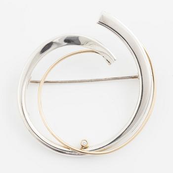 Brosch silver med en rund briljantslipad diamant.