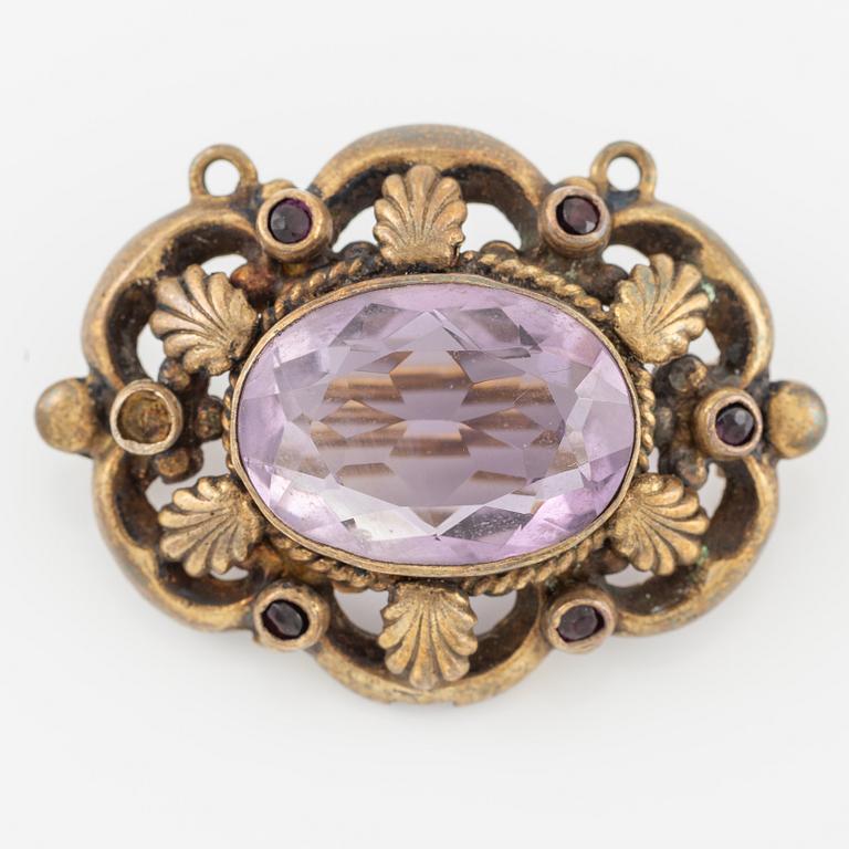 Brooch, gilded metal with a faceted amethyst.