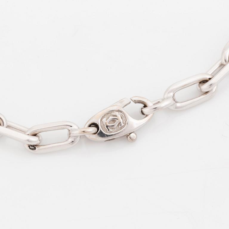 An 18K white gold Cartier "Spartacus" bracelet with two charms.