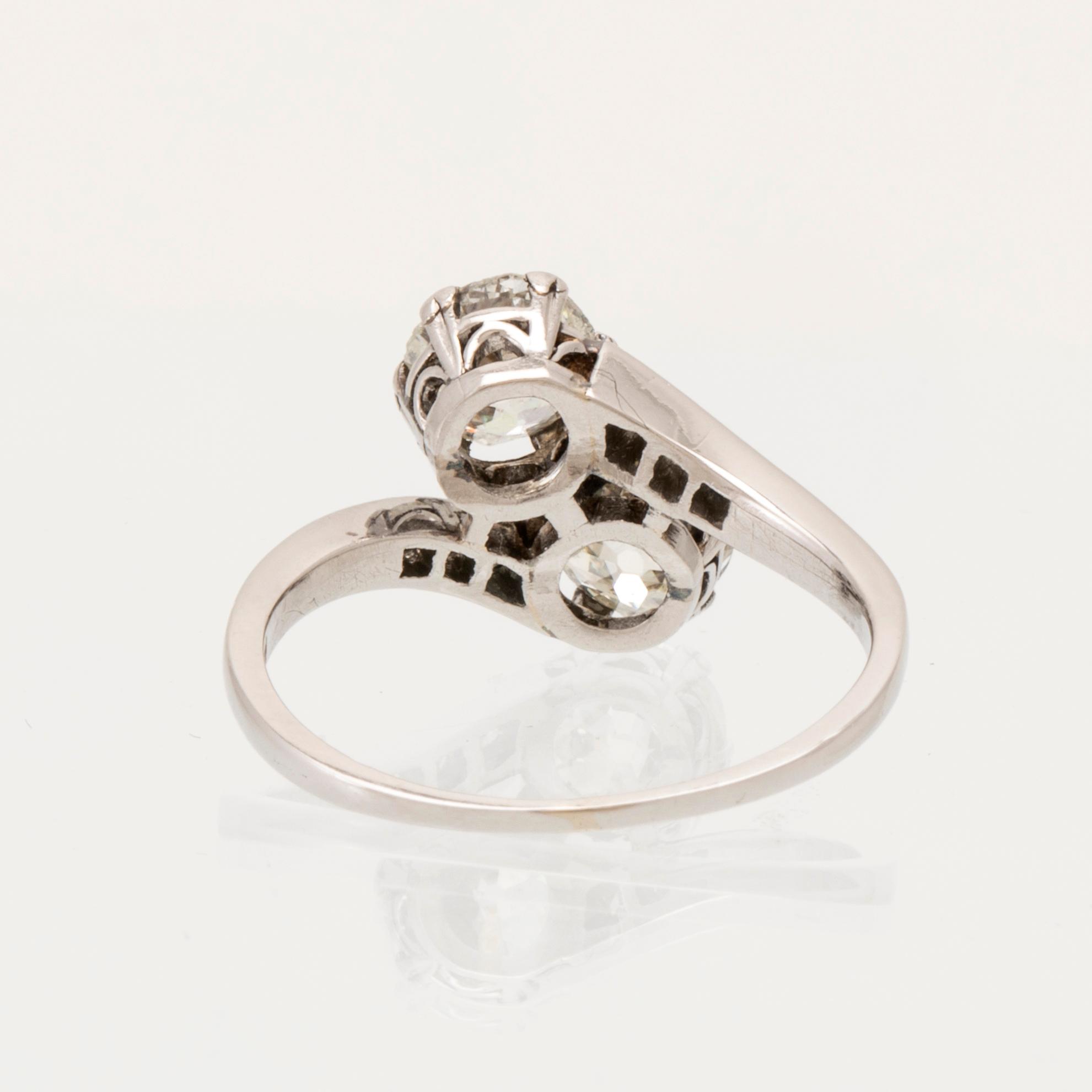 A platinum ring "sibling ring/twin ring" set with round old-cut and brilliant-cut diamonds.
