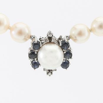 Necklace of cultured pearls with an 18K white gold clasp and round single-cut diamonds and round faceted sapphires.