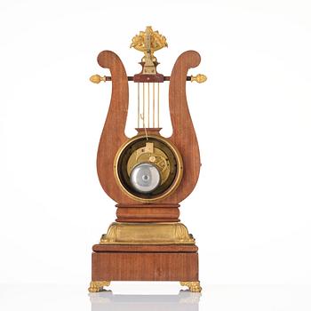 A French Empire mahogany, ormolu and gilt metal lyre-shaped mantel clock, early 19th century.