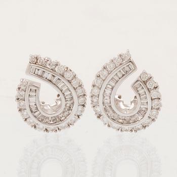 A pair of 18K white gold earrings set with round brilliant-cut and tapered baguette-cut diamonds.