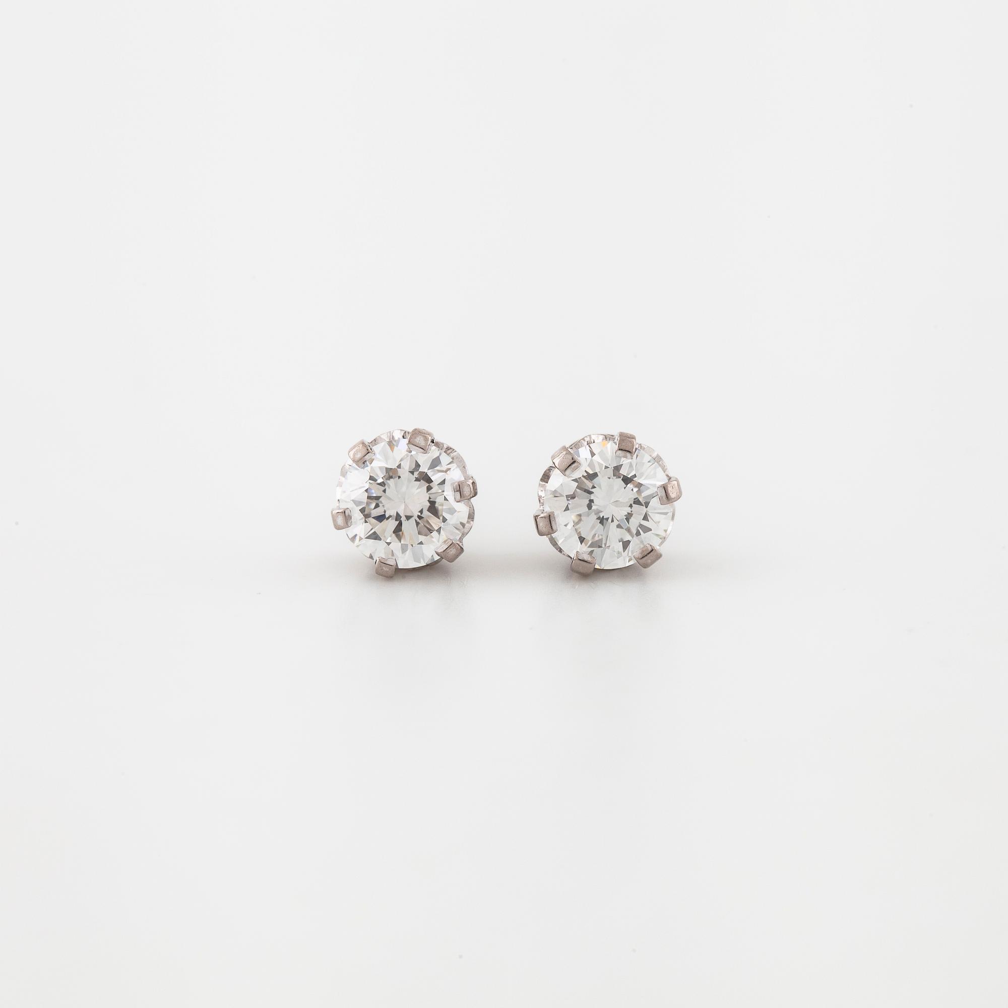 A pair of brilliant cut diamond earrings.