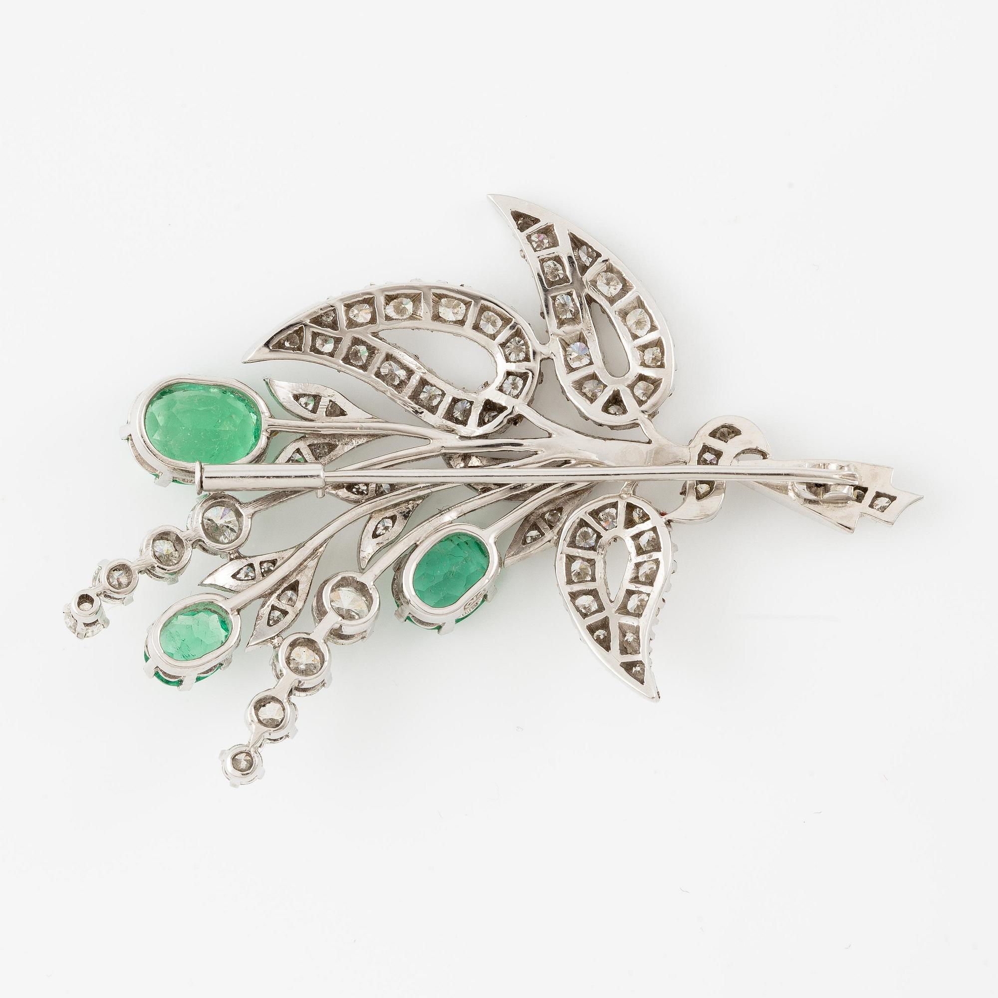 Brooch 18K white gold in the form of a bouquet with emeralds and octagonal and round brilliant-cut diamonds.