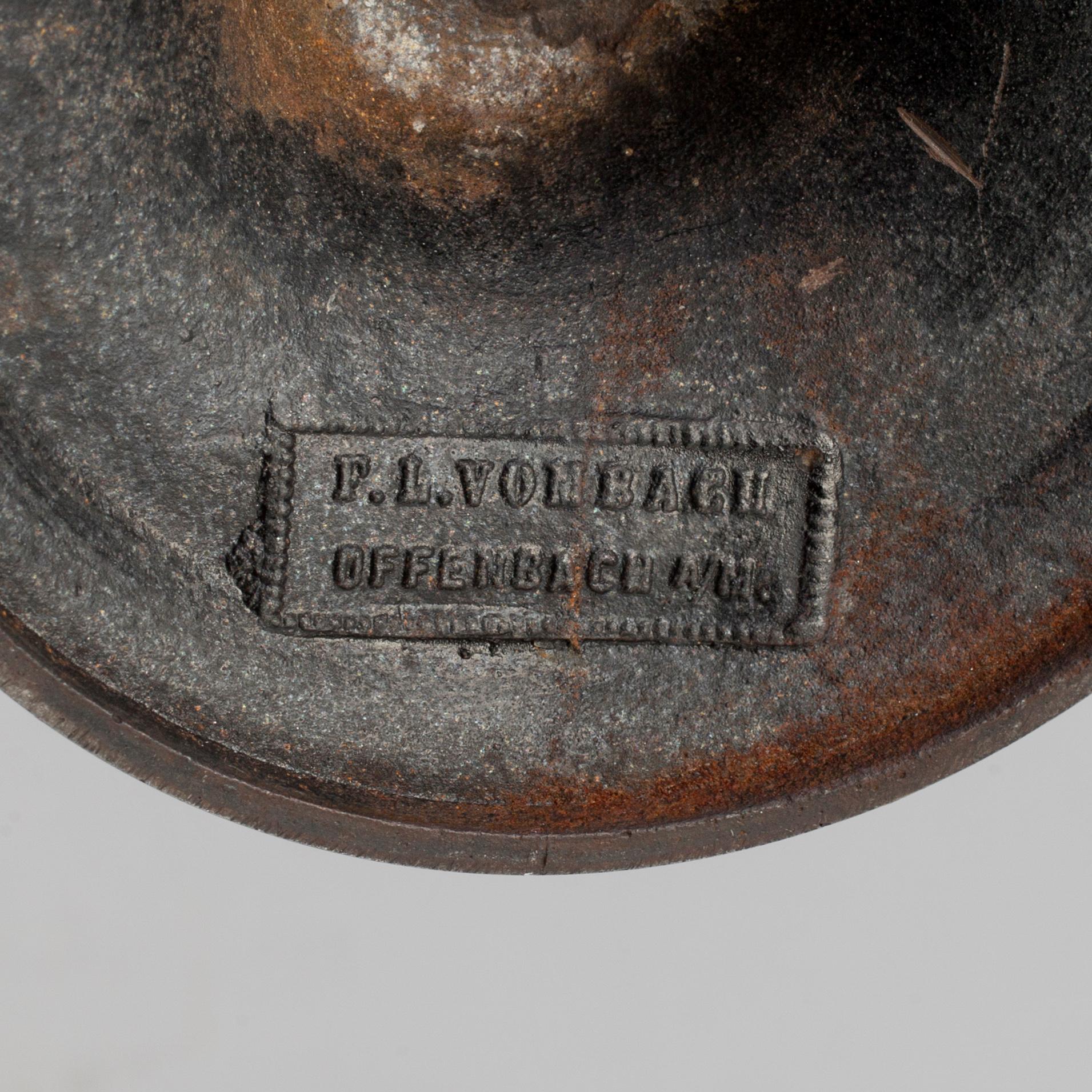 A 19th century iron candlestick marked F.L Vombach Offenbach A/M.