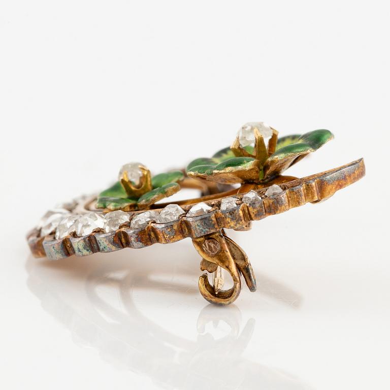 A brooch in the form of a crescent moon in 14K gold  with enamel and rose-cut diamonds.