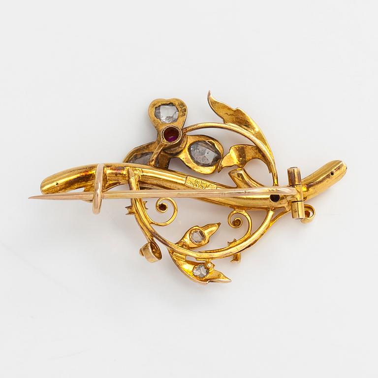 A 14K gold brooch set with rose-cut diamonds and a ruby.