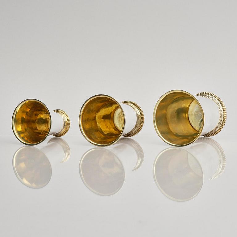 Three Swedish 18th century parcel-gilt silver beakers and a case of birch, different maker's.