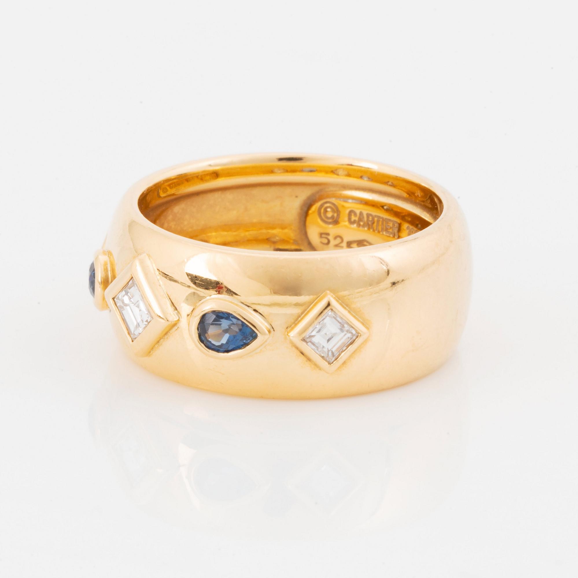 An 18K gold Cartier ring set with step-cut diamonds and faceted sapphires.