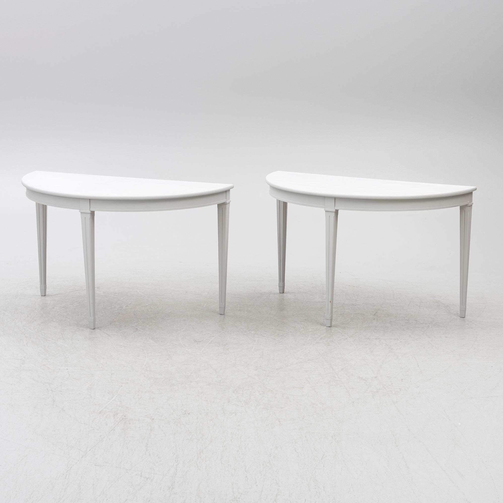 A pair of crescent shaped tables, 20th century.