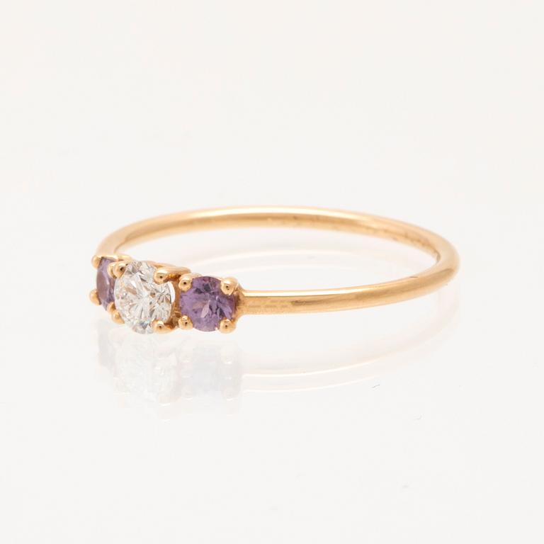 Ring "Edith" 18K guld med en rund briljantslipad diamant samt två rosa/lila safirer, Mumbaistockholm, Stockholm 2023.